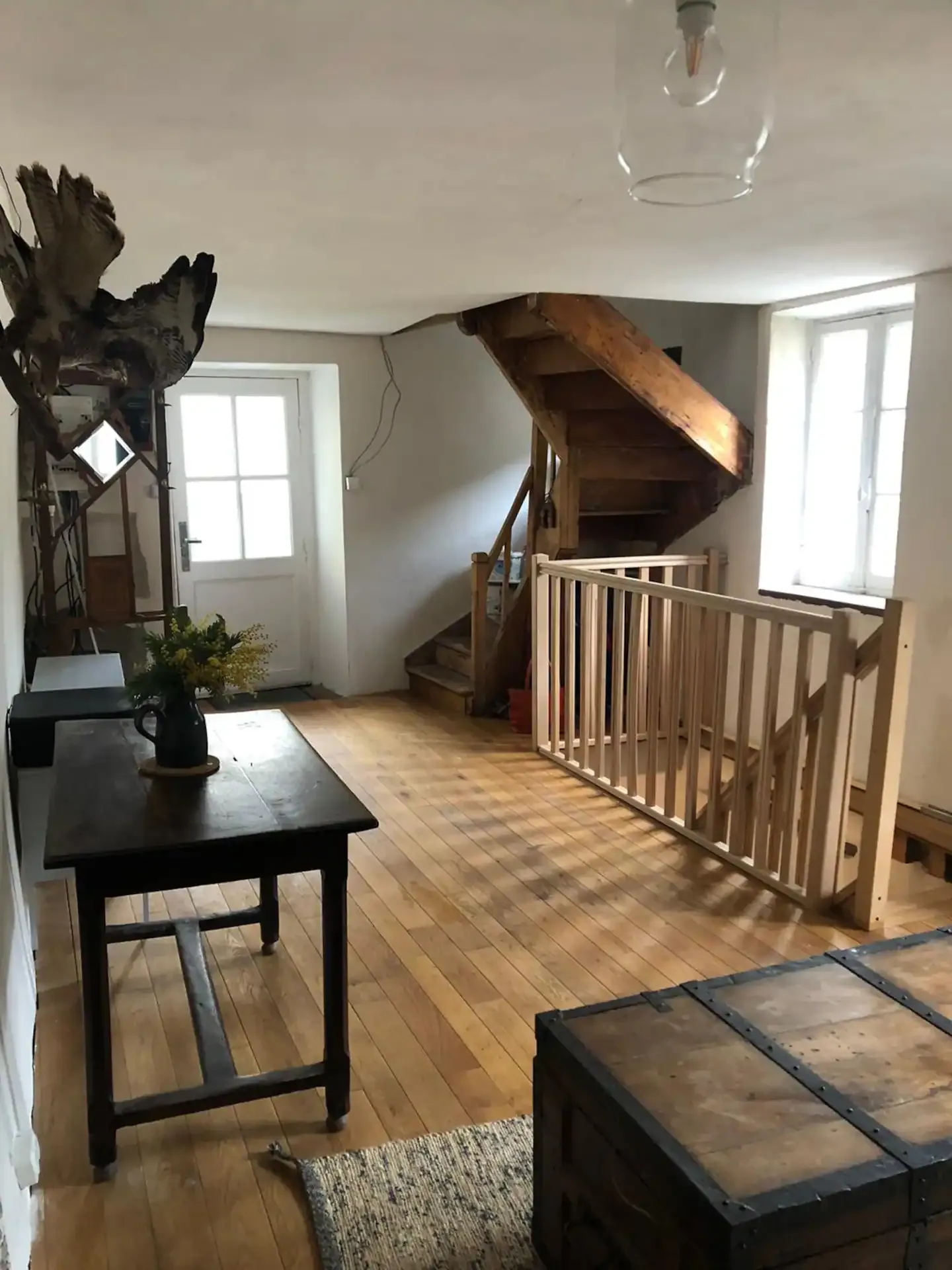 L’entrée de la maison : parquet, escalier en bois et table ancienne