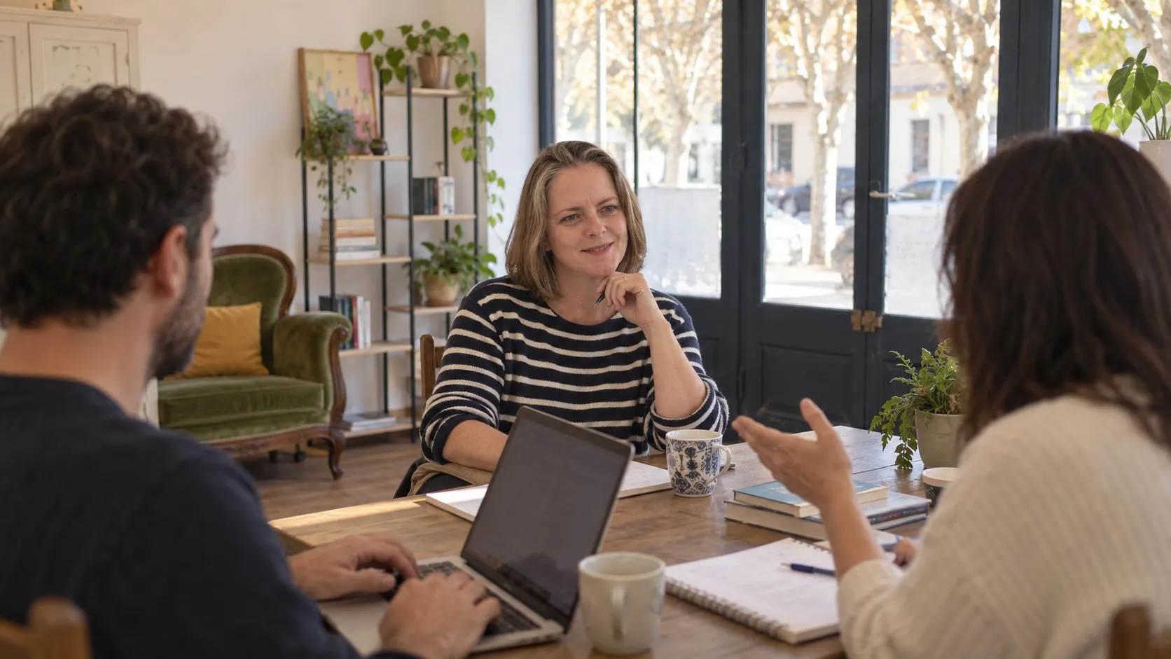 Helen en cours avec deux adultes autour d’une table de la salle, un ordinateur ouvert
