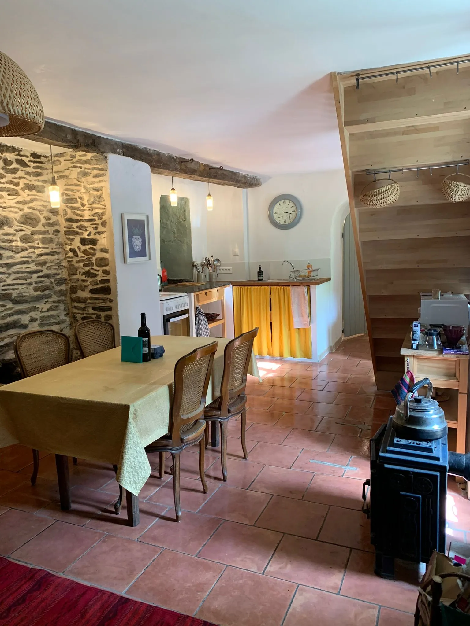 La cuisine et sa grande table, tomettes et poêle à bois