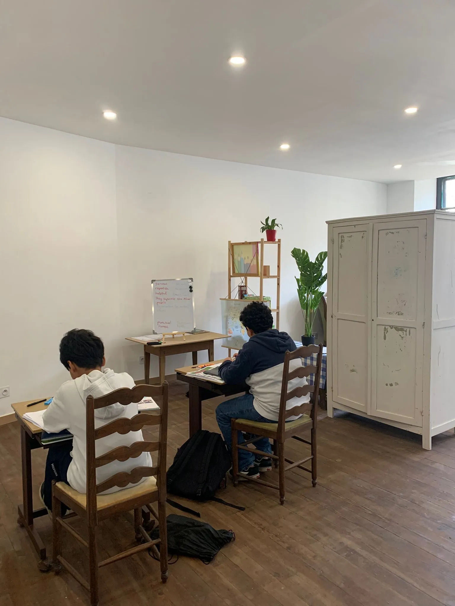 Deux élèves au travail à leur table, dans la salle