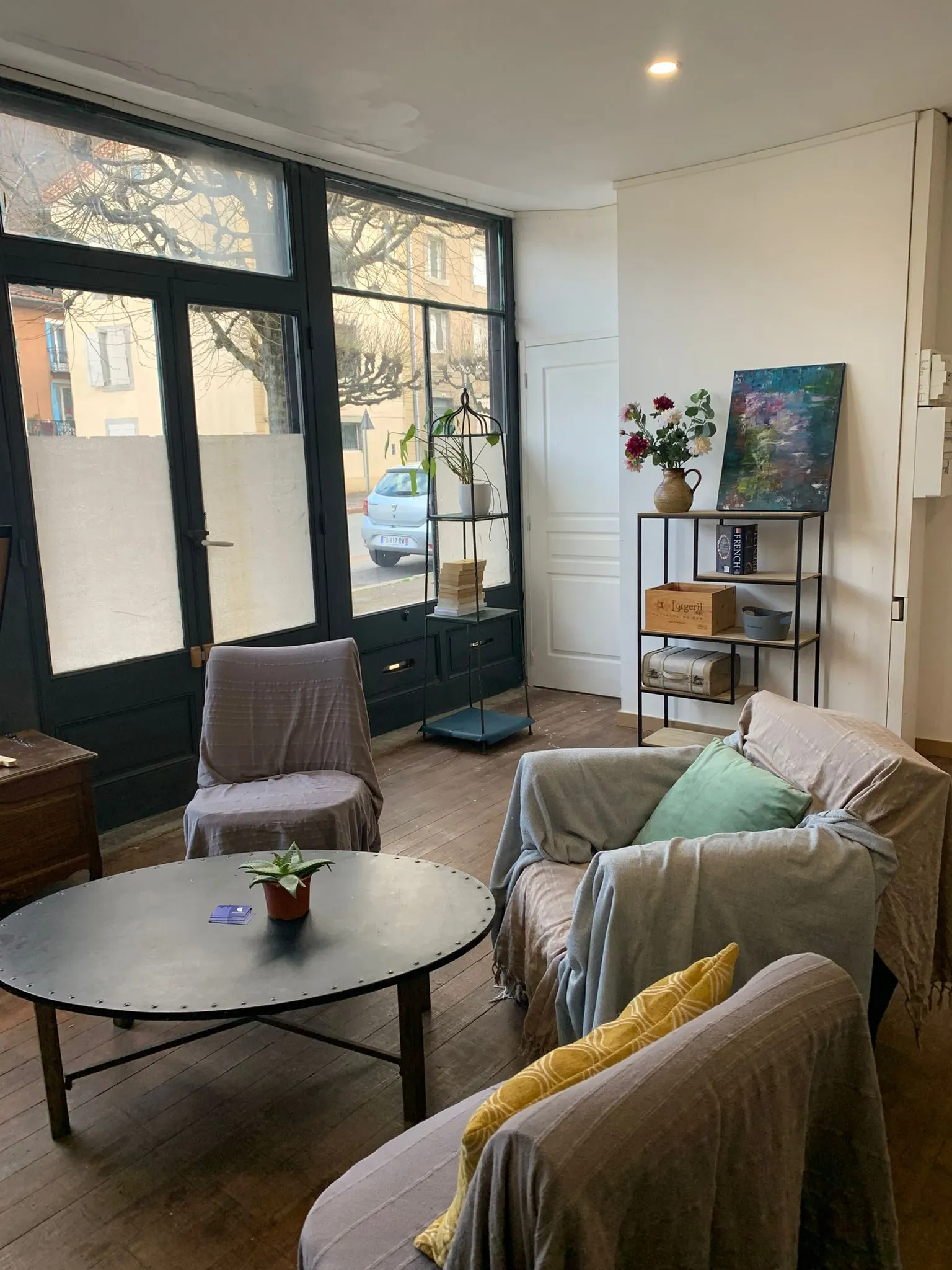 Le coin salon : fauteuils, table basse et fleurs devant la fenêtre